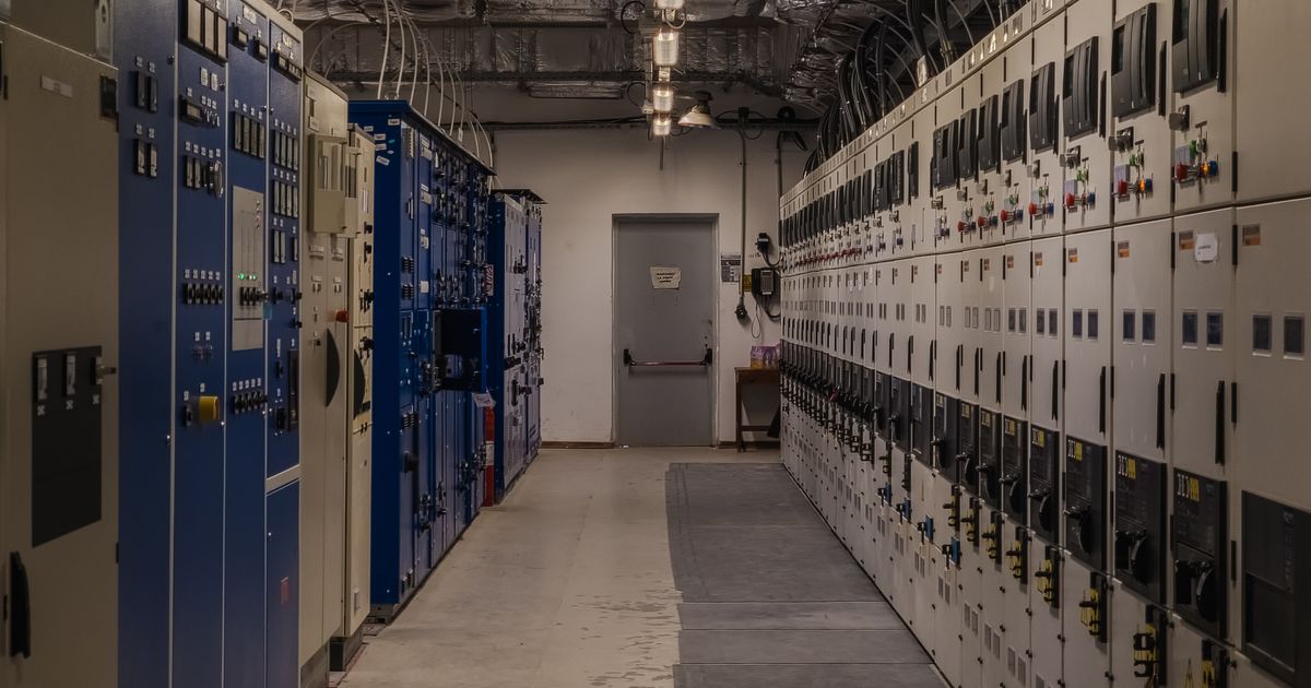 Techniker überwacht Schaltanlagen in einem Gebäudeleitstand für technisches Facility Management