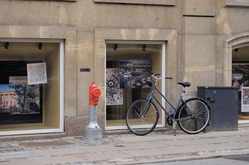 Free Bicycle parked against a building in Copenhagen, Denmark, with a red fire hydrant nearby. Stock Photo