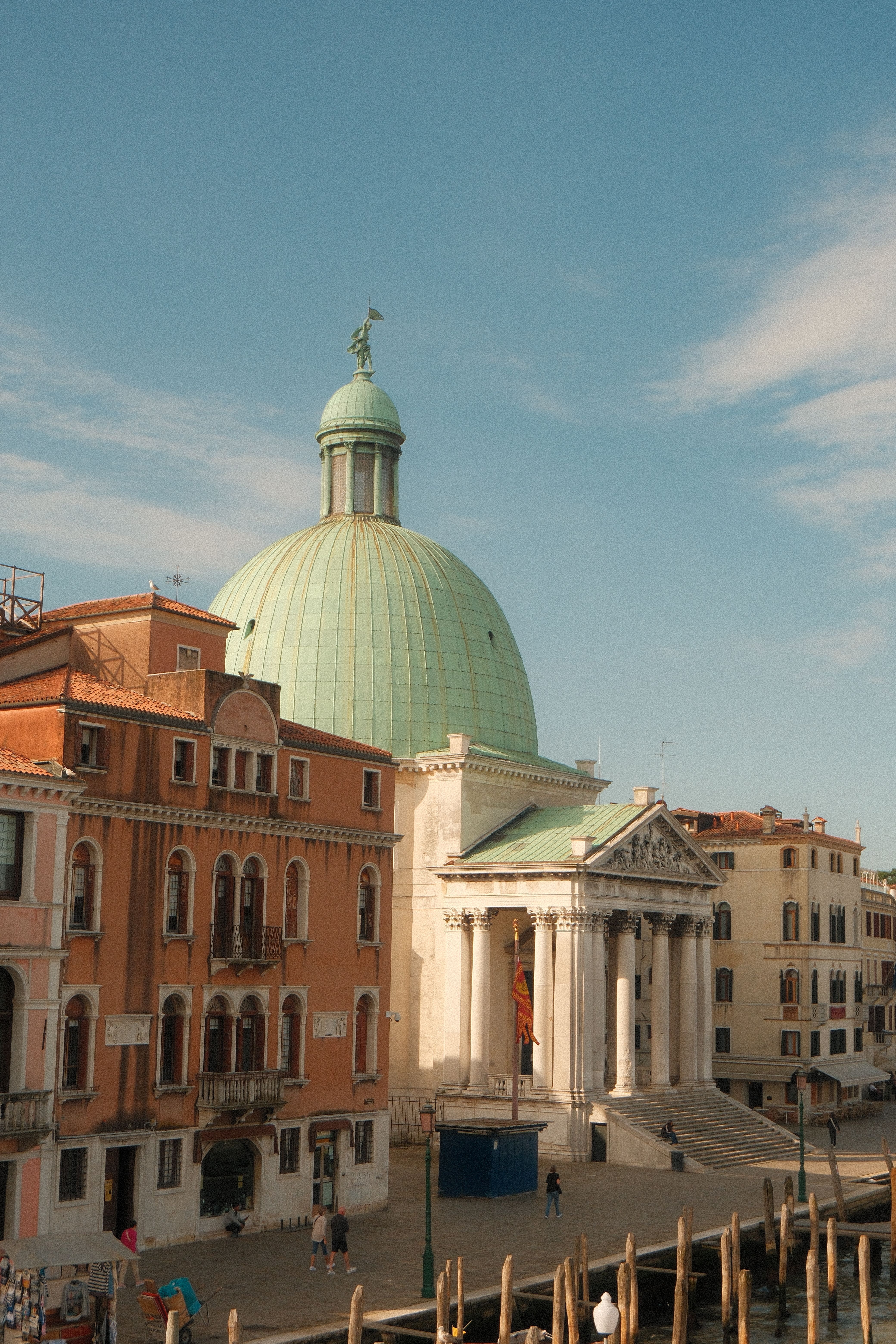Iconic church dome of San Simeone Piccolo against Venice's historic architecture and blue sky.