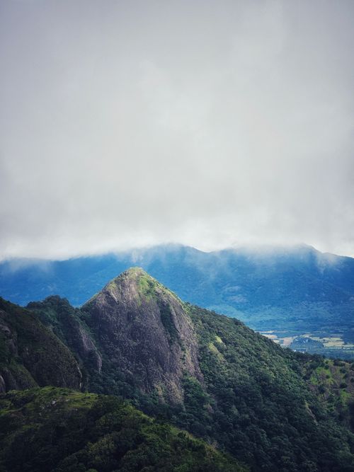 Free Stunning view of rugged green mountains with overcast sky creating a serene and dramatic landscape. Stock Photo