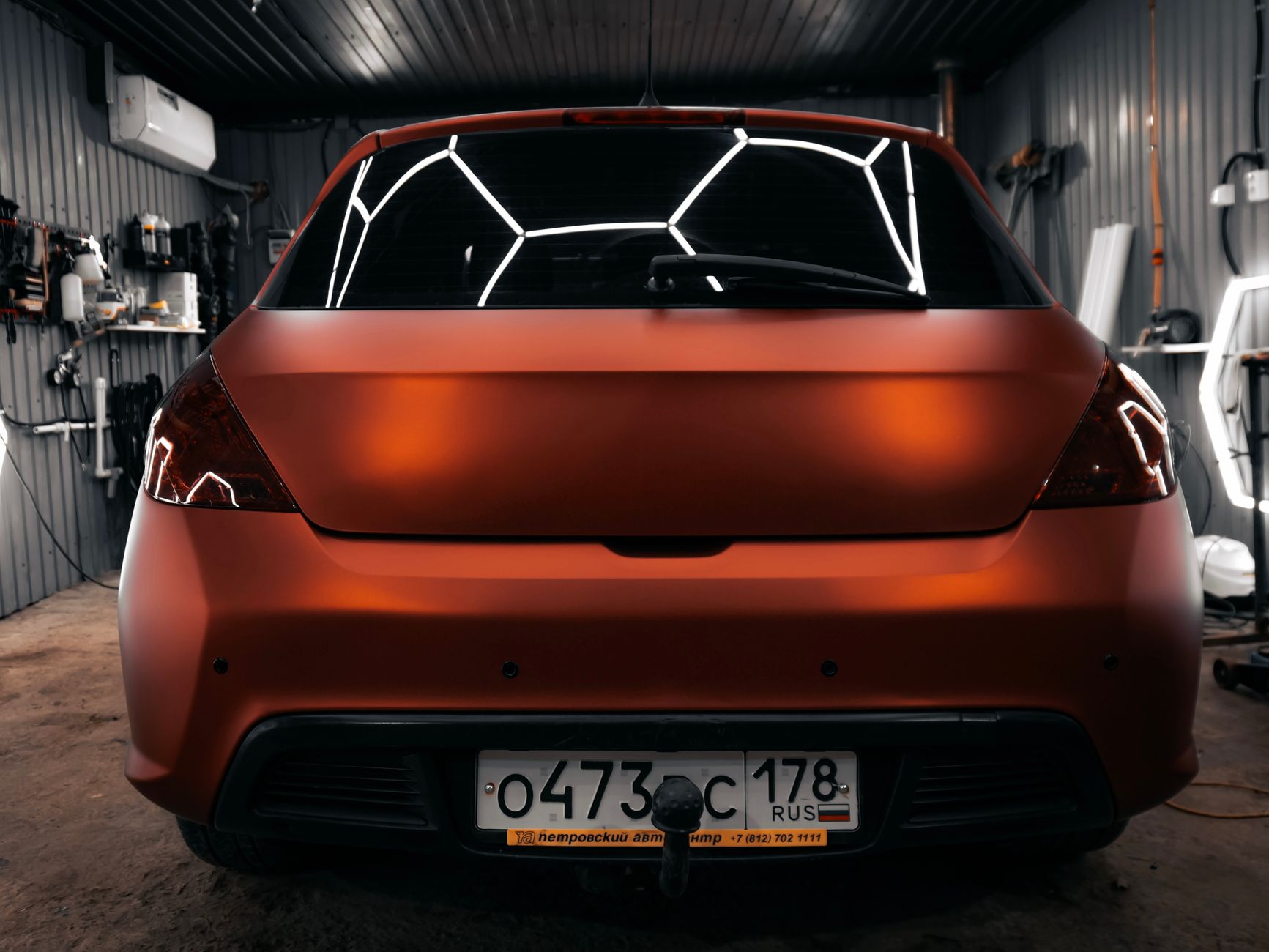 Glossy orange car under studio lights