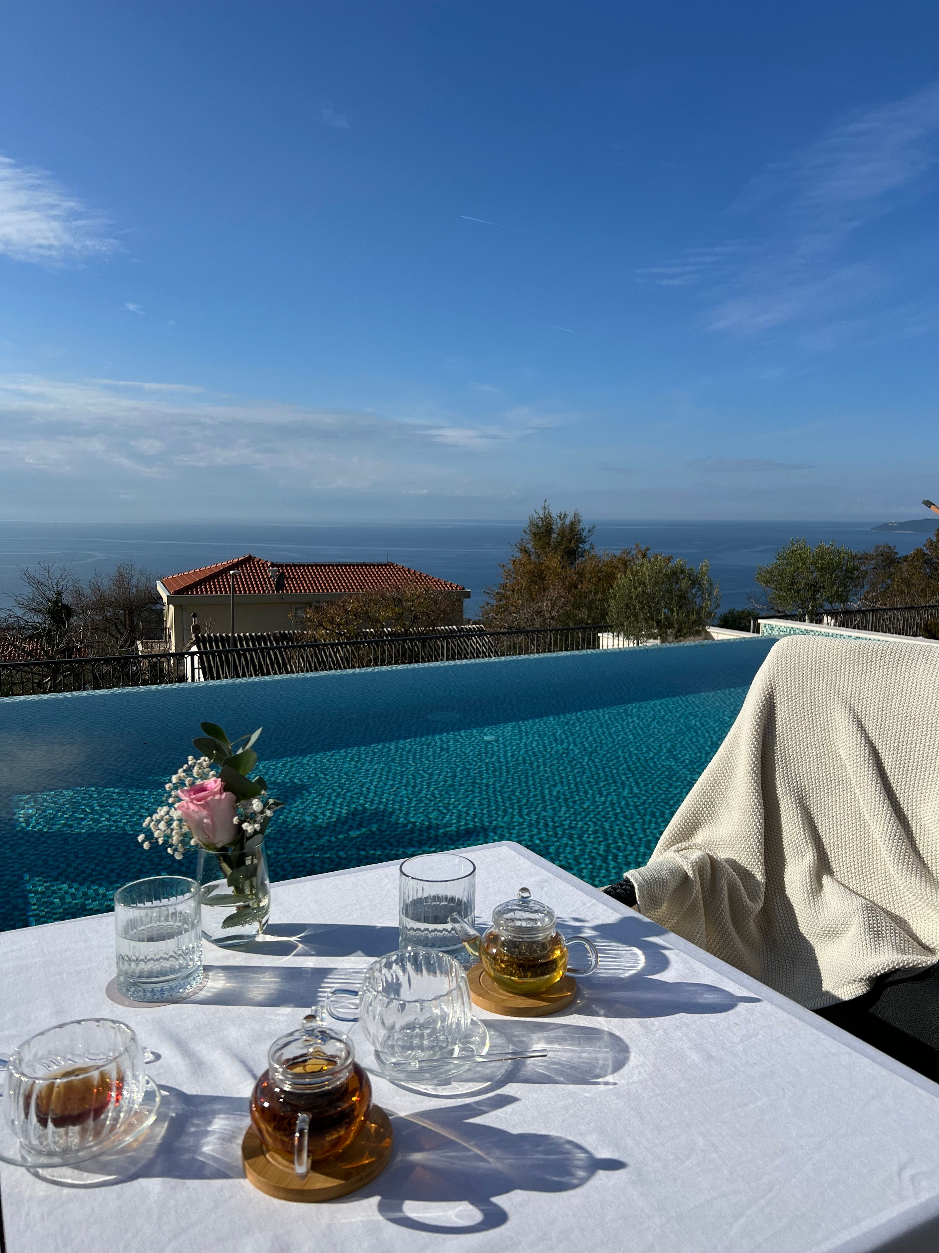 Enjoying a tranquil tea time by the pool with stunning Montenegro sea views, offering a peaceful atmosphere.