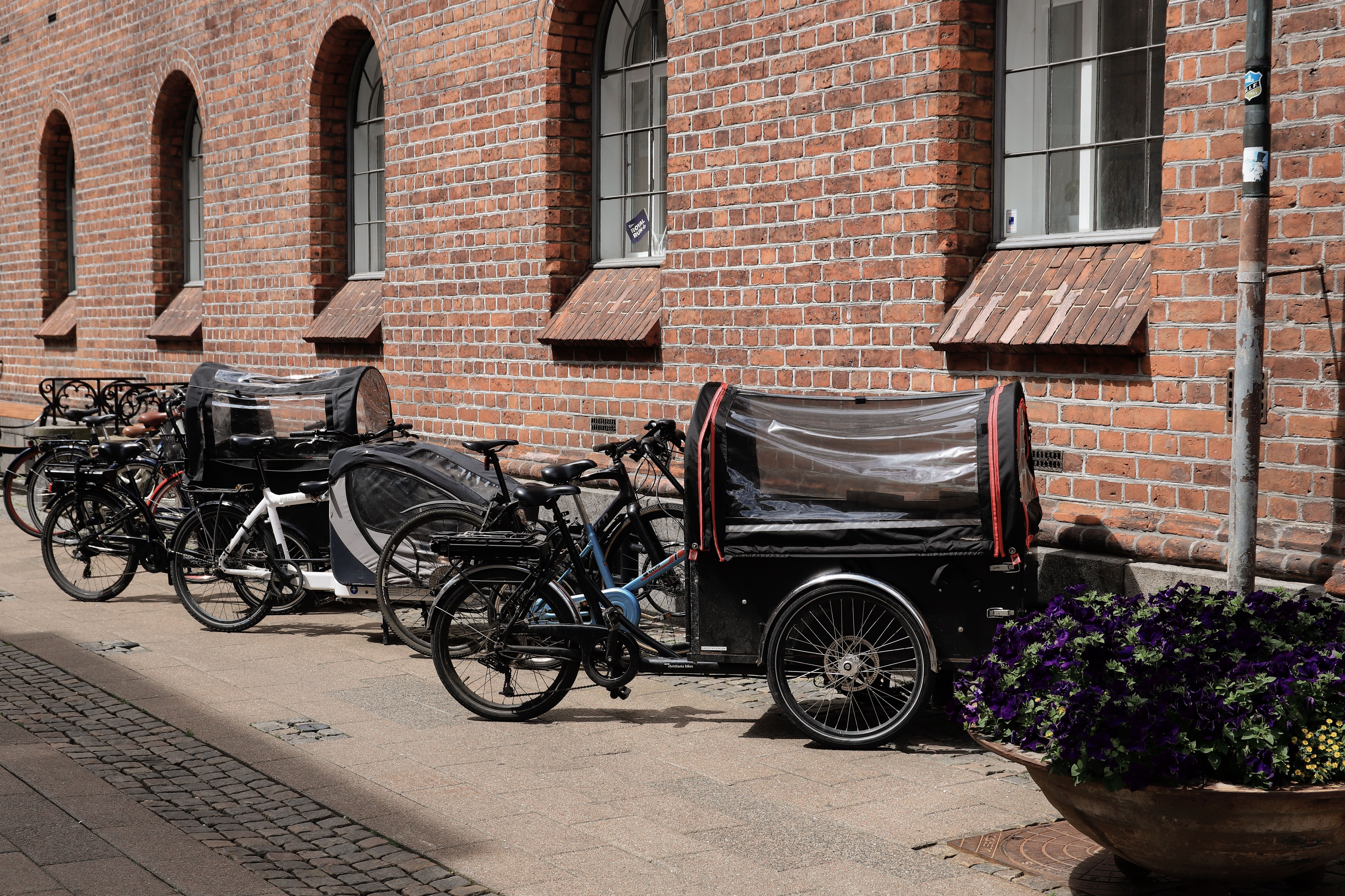 Cargo bikes parked along a brick wall in Copenhagen, part of the city's cycling culture