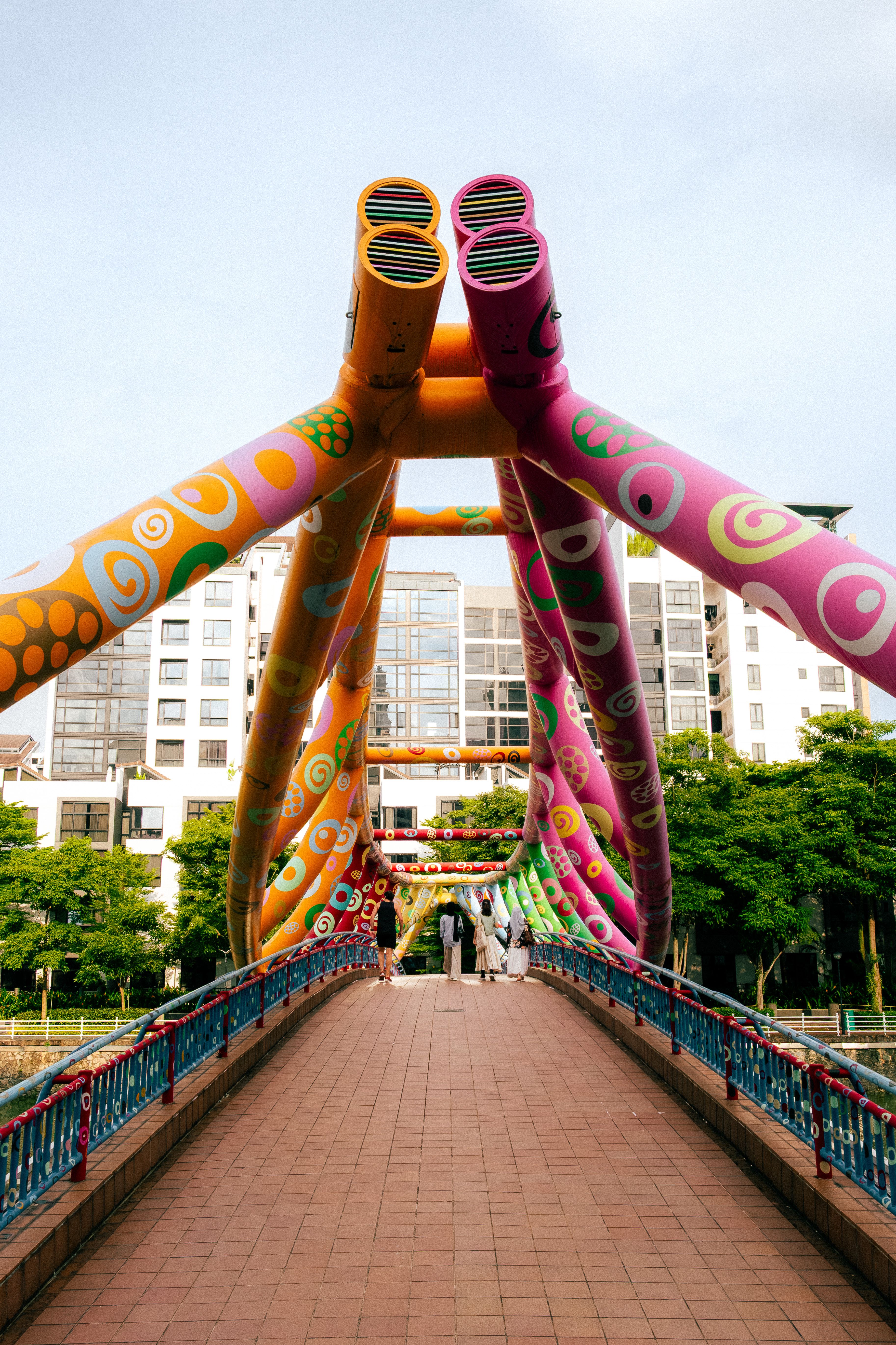 Vibrant spiral bridge in Singapore with colorful artistic designs and urban backdrop.