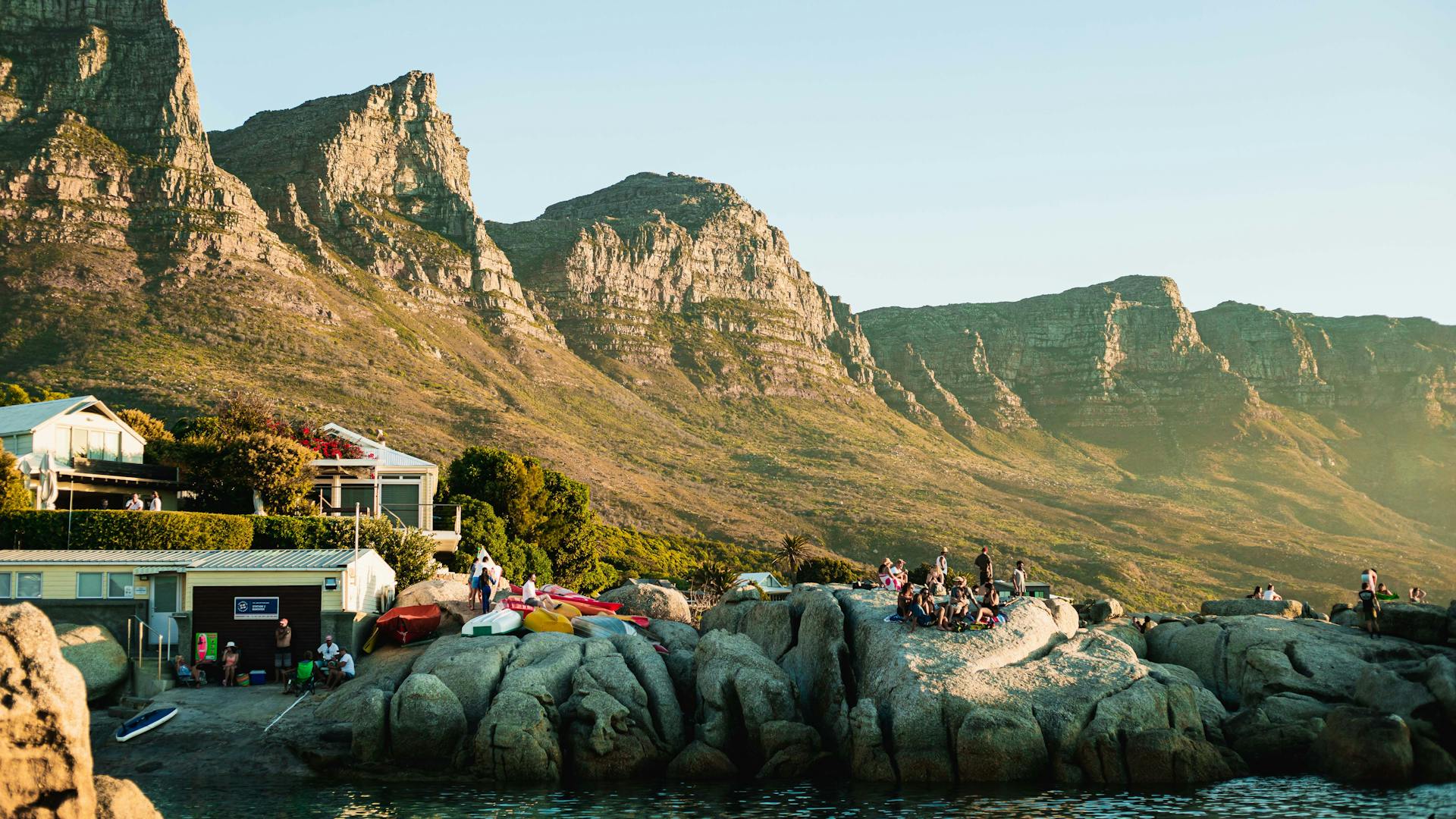 Sunny day at Camps Bay, Cape Town with stunning mountain backdrop and lively waterfront scene.