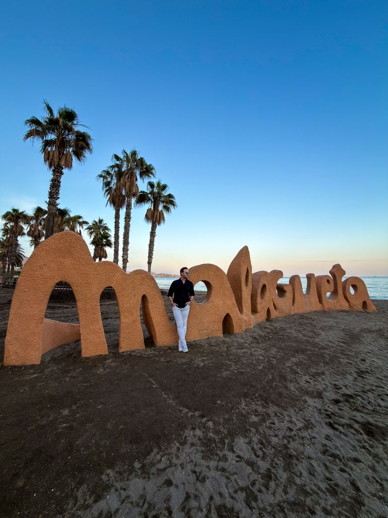 Malagueta name sign sculpted in sand on the beach in Málaga