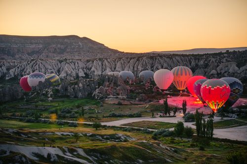 Free Breathtaking sunrise with hot air balloons over Cappadocia's unique landscape in Nevşehir, Türkiye. Stock Photo