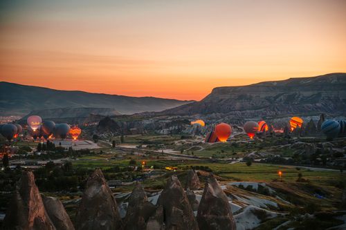 Free Breathtaking view of Cappadocia hot air balloons at sunrise, capturing the natural beauty and excitement of Nevşehir, Türkiye. Stock Photo