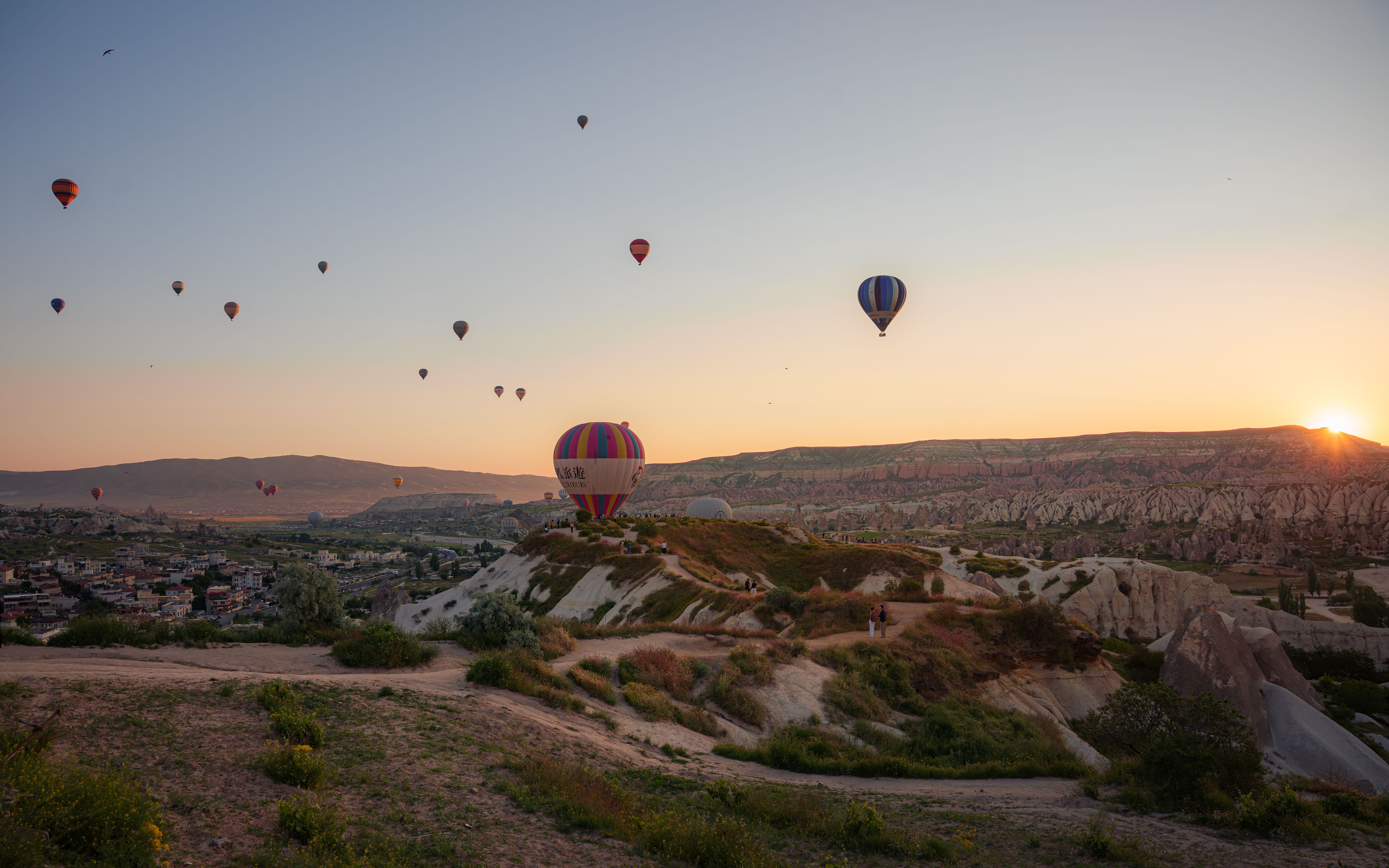 Hot air balloons rising over the rock valleys of Cappadocia at sunrise.