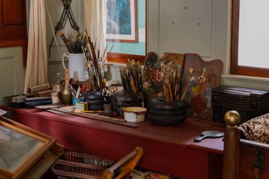 Cozy artist's studio with brushes, palettes, and vintage decor in New York.