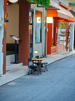 Charming small cafe tables with chairs on a quiet urban street, perfect for leisure.