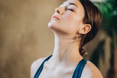 Tranquil indoor portrait of a woman in a calm and peaceful state with eyes closed.