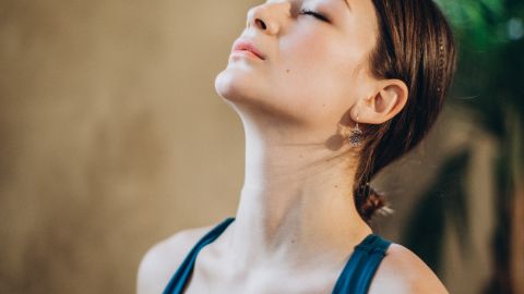 Tranquil indoor portrait of a woman in a calm and peaceful state with eyes closed.