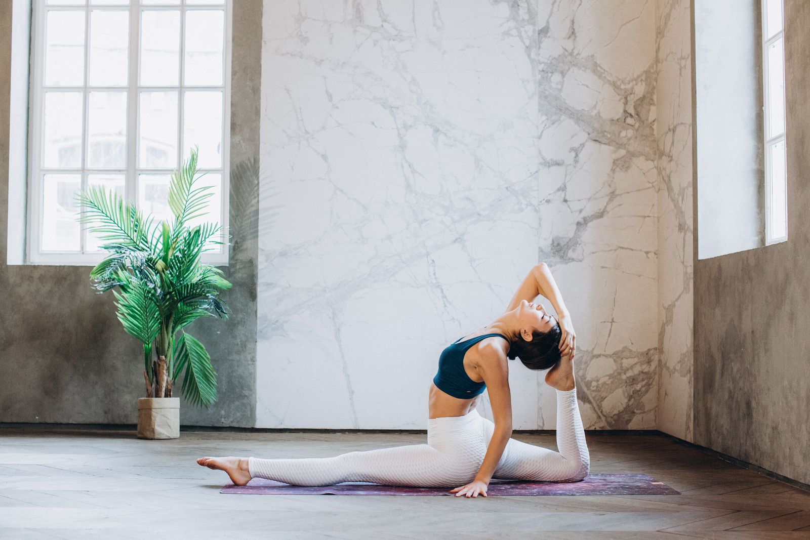 Woman practicing a seated yoga forward fold to stretch and support leg circulation