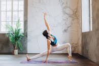 在阳光明媚的现代工作室里，一位身姿灵活的女性正在表演瑜伽姿势，展现出平衡与力量