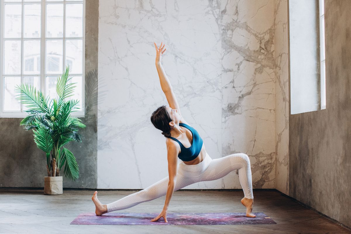 Woman practicing yoga in a bright, sunlit studio