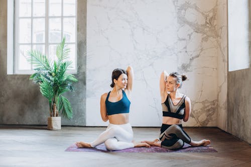 2 Women Sitting on Galaxy Design Yoga Mat