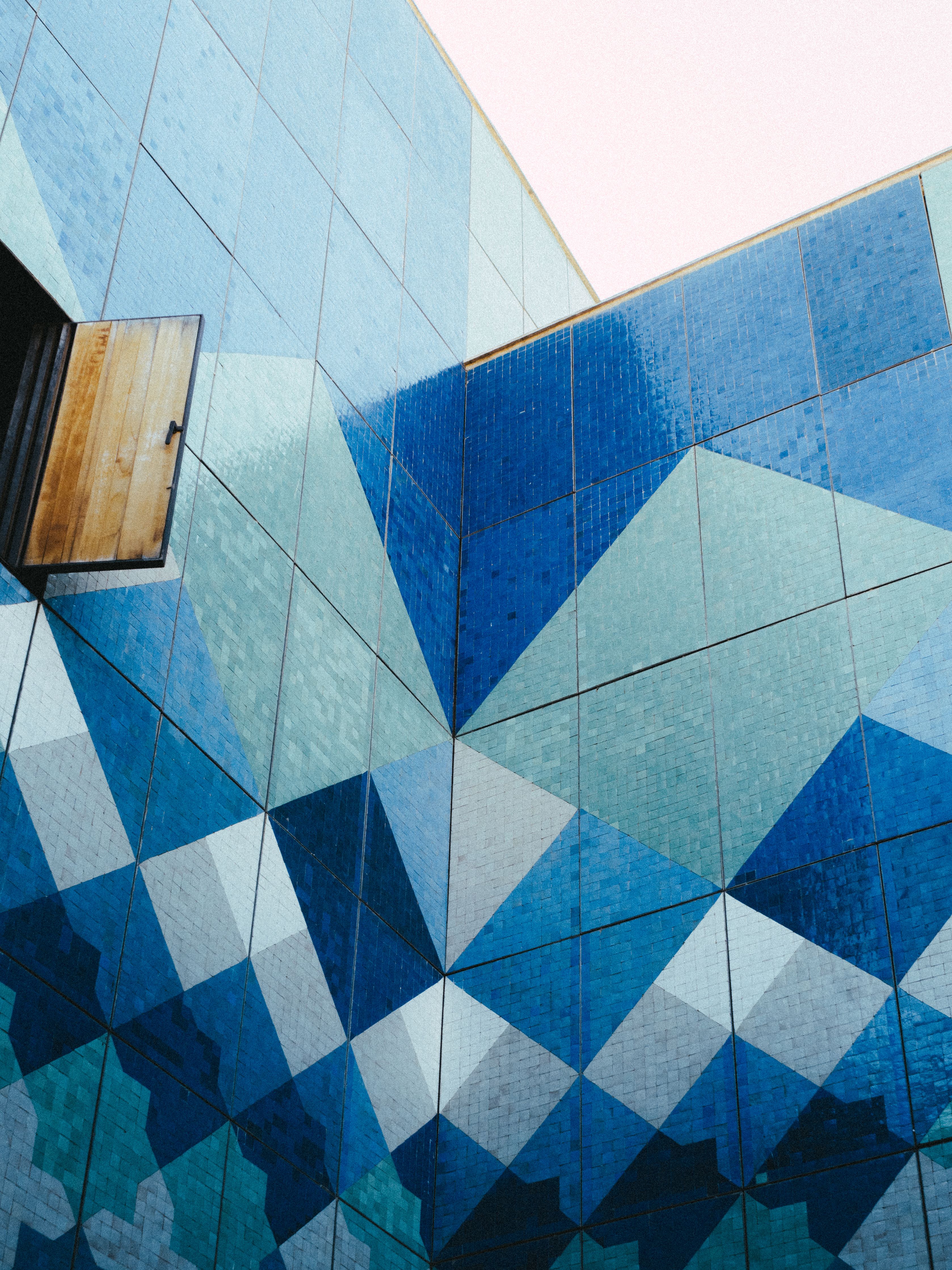 Colorful geometric wall with open window in Fes, showcasing vibrant Moroccan architecture.