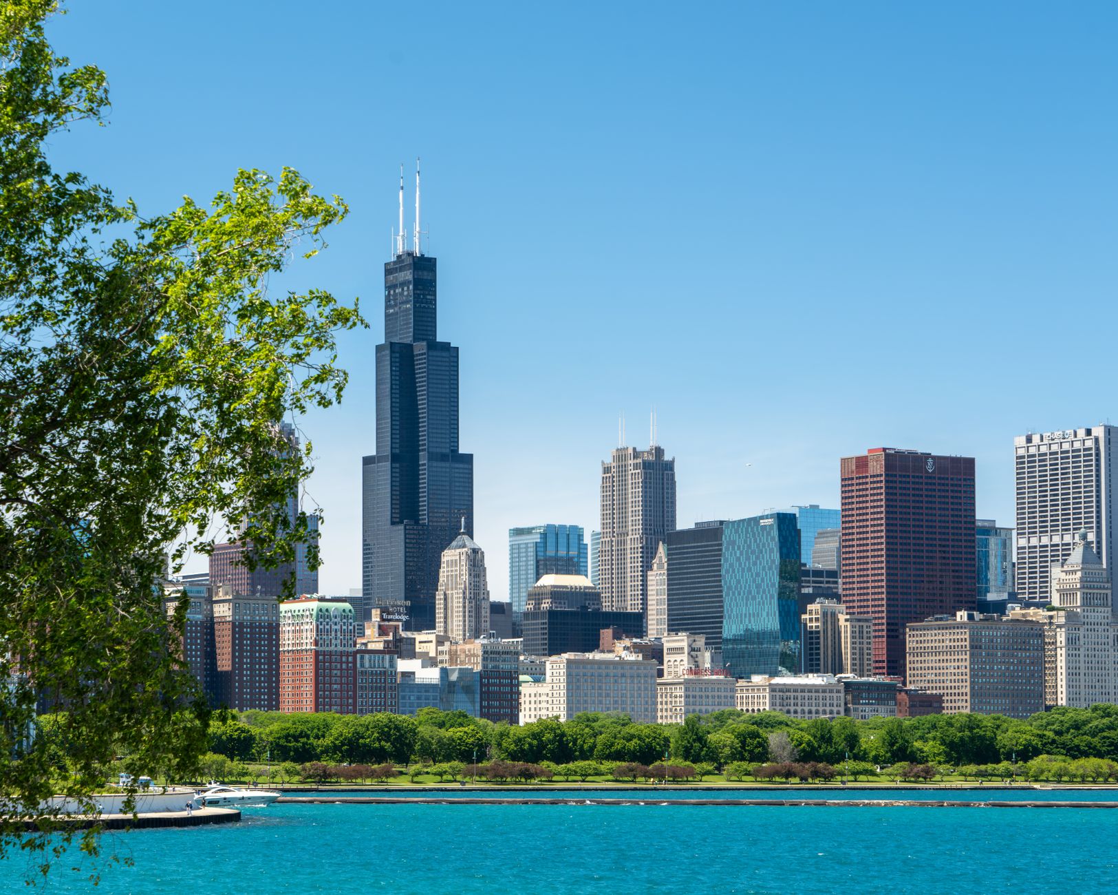 Door hanger delivery in Chicago, IL Door hanger distribution and flyer delivery in Chicago, IL — A vibrant view of Chicago skyline featuring the iconic Willis Tower under clear summer skies. above neighborhoods DoorBlitz crews walk
