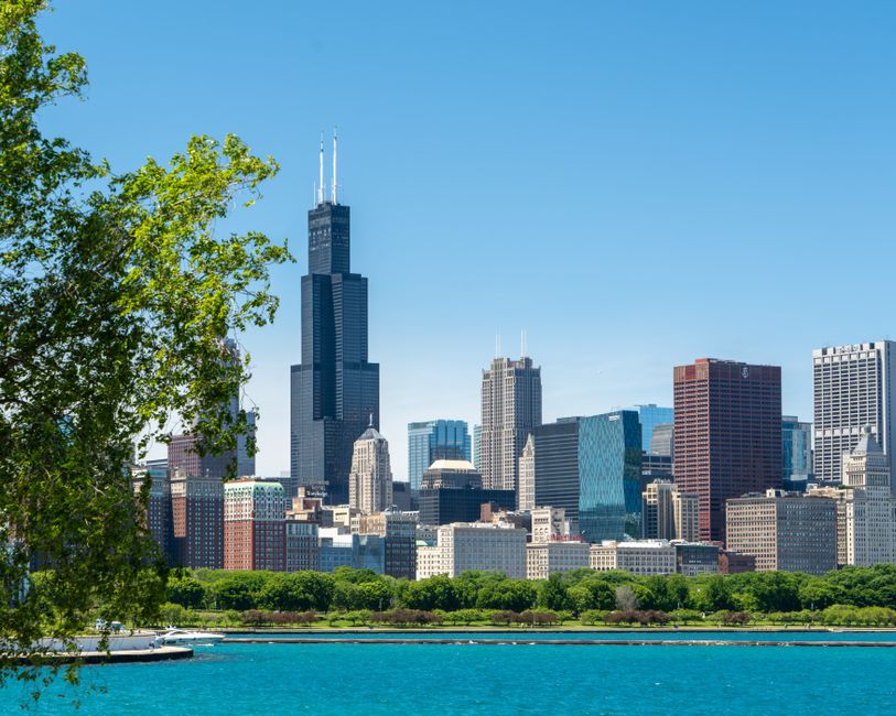 A vibrant view of Chicago skyline featuring the iconic Willis Tower under clear summer skies.