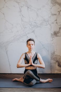 女子靠在大理石墙上冥想瑜伽，象征着专注和放松