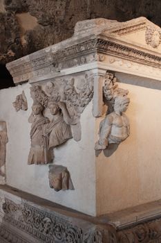 Ornate Roman stone tomb with detailed relief sculptures, showcasing classical art.