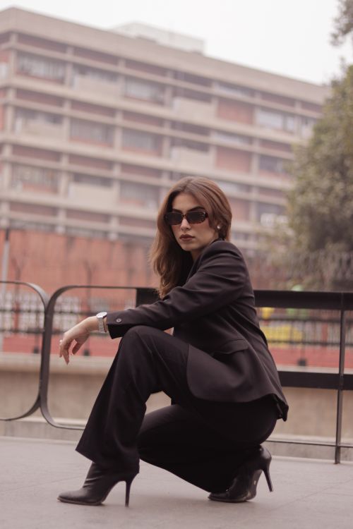Free Confident woman in black suit posing outdoors with urban background. Stock Photo