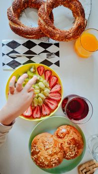 Top-down view of a colorful breakfast spread including pastries, fruits, and drinks.