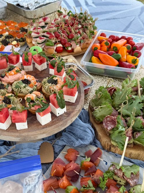 Free An array of vibrant, gourmet appetizers at an outdoor picnic, featuring fresh fruits and gourmet bites. Stock Photo