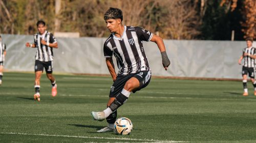 Free Athlete dribbling a soccer ball during an outdoor match on a sunny day. Stock Photo