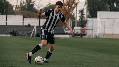 Free Dynamic shot of a soccer player dribbling on a grassy field during a match. Stock Photo