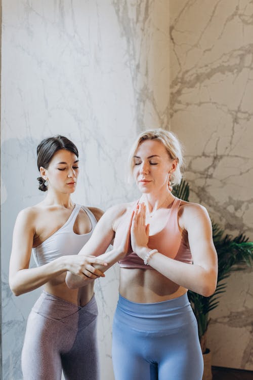 Free Yoga Instructor Helping a Student Stock Photo