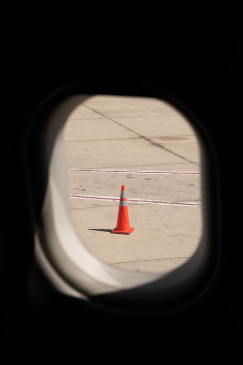 Free Traffic cone seen from an airplane window on a sunny day at the airport. Stock Photo