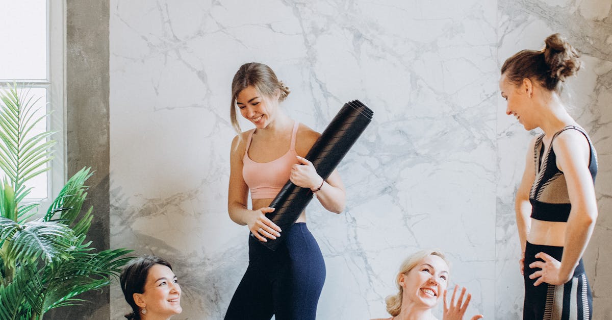 A cheerful group of women practicing yoga together indoors, promoting a healthy lifestyle.