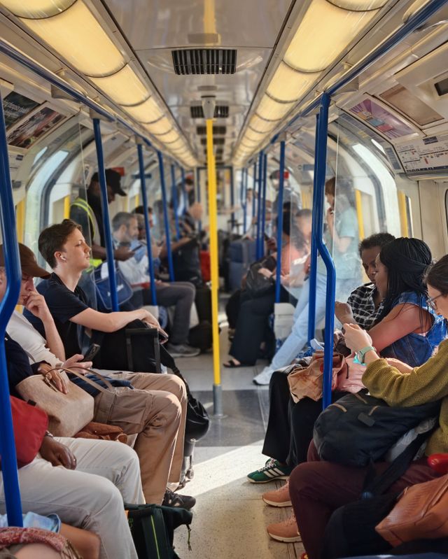 Commuters on a London Tube train during the day.