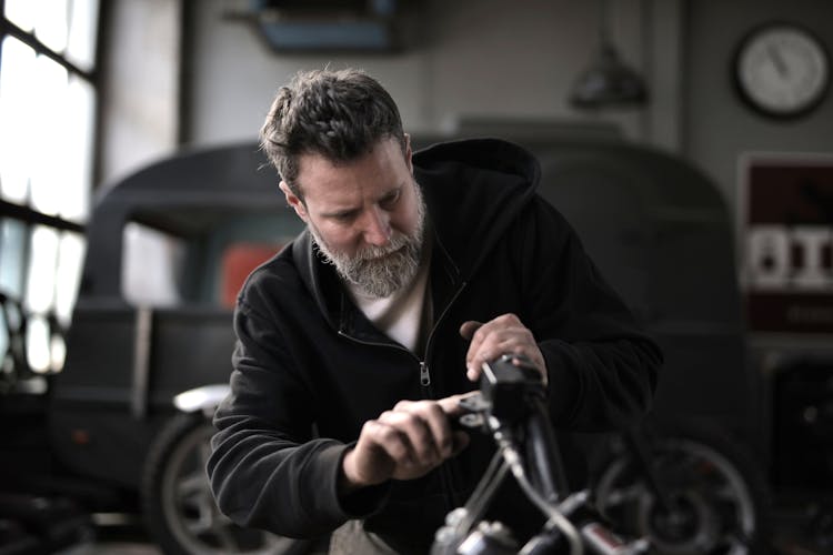 Brutal Man Repairing Motorbike In Workshop