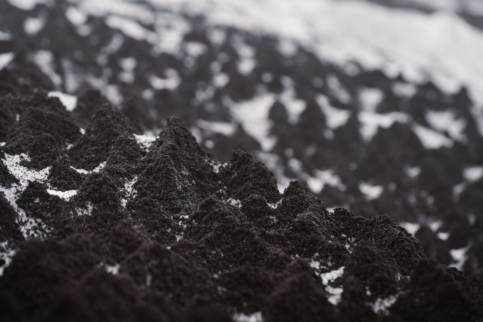 Detailed view of rugged black volcanic ash, creating a unique texture and pattern.