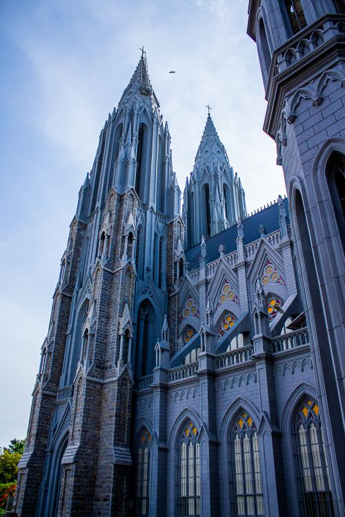 Free Dramatic shot of a gothic cathedral's architecture reaching into the clear blue sky, showcasing ornate details. Stock Photo