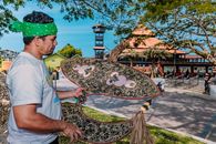Man Holding Traditional Malaysian Kite Outdoors