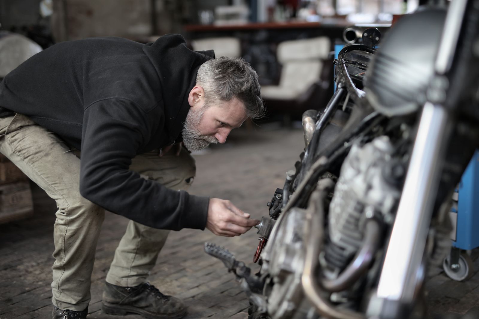 Homme examinant sérieusement les détails d'une moto dans un garage