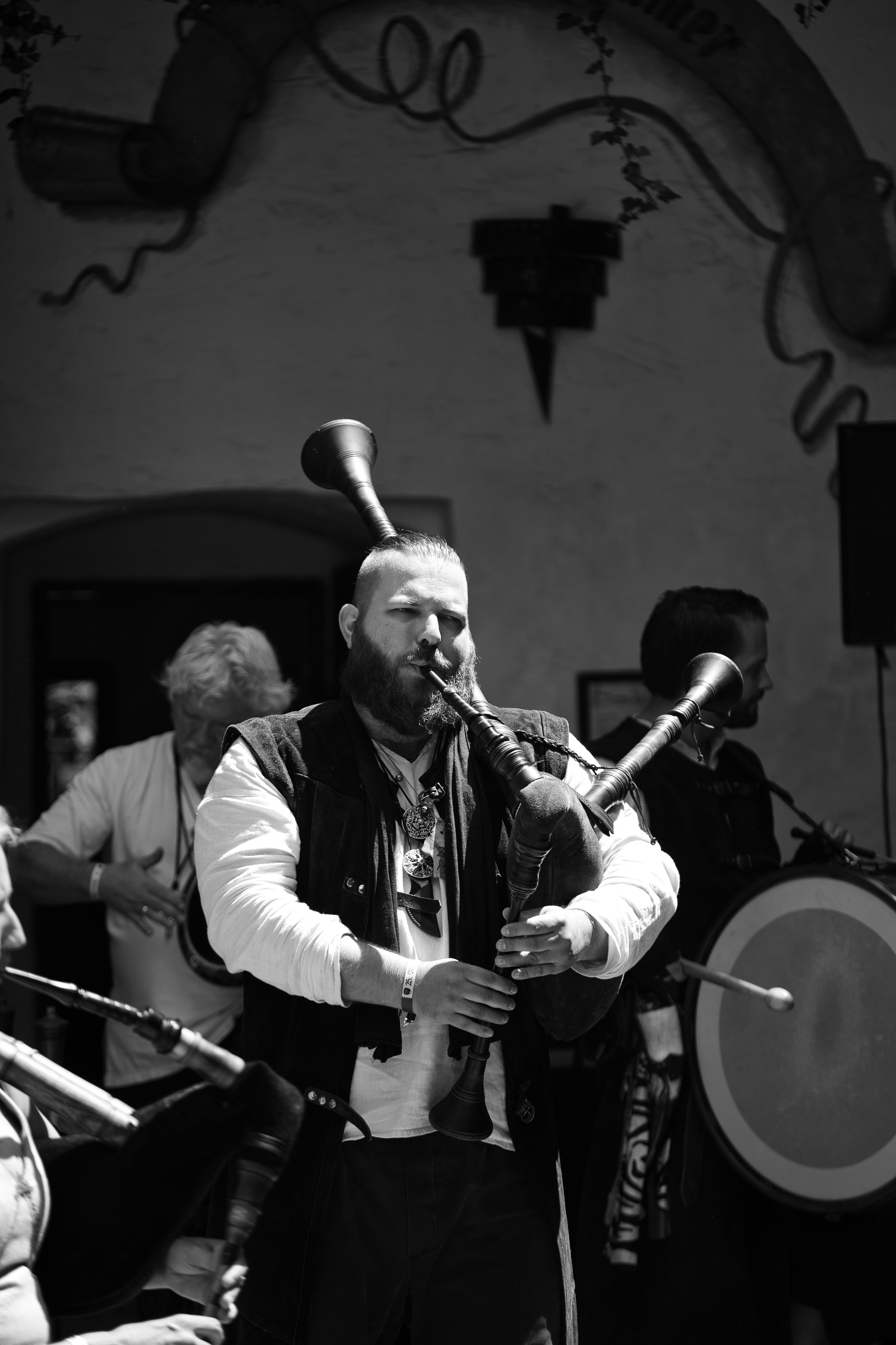 Black and white photo of a musician playing bagpipes at a traditional event in Kapfenberg, Austria.