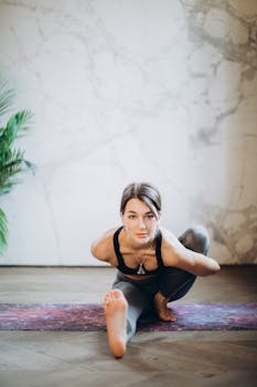 Woman demonstrating Marichyasana yoga pose indoors, focusing on fitness and relaxation.