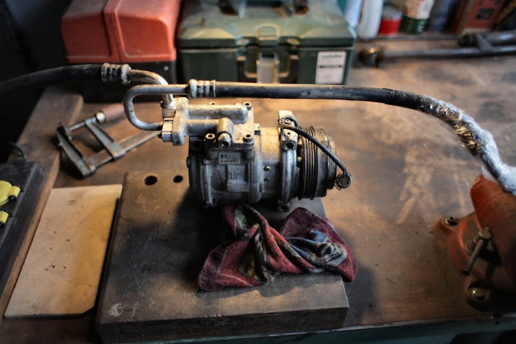 Metal Air Conditioning Compressor On Workbench In Garage