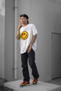 Hipster ethnic guy in trendy outfit standing on concrete platform