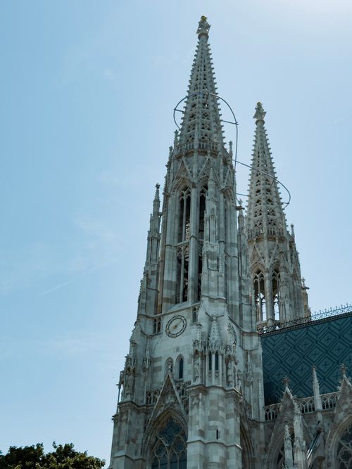 Free Capture of the iconic neo-Gothic Votivkirche spires set against a clear blue sky in Vienna. Stock Photo