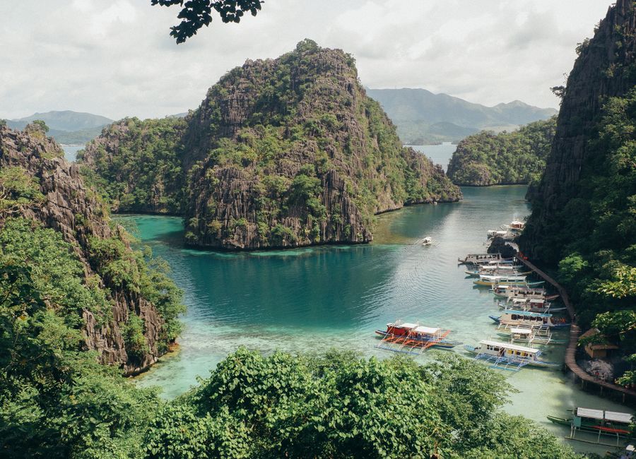 Explore Coron Bay, a tropical paradise with clear waters and limestone cliffs in the Philippines.