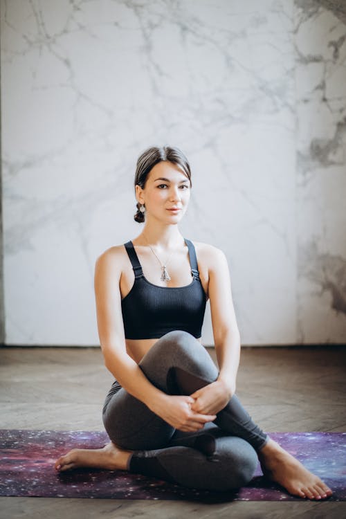 Free Woman in Black Tank Top and Black Leggings Sitting on Floor Stock Photo