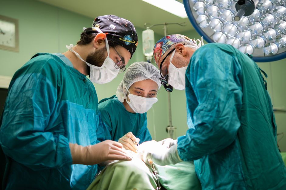 A focused surgical team operating in a brightly lit hospital room, showcasing teamwork and precision.