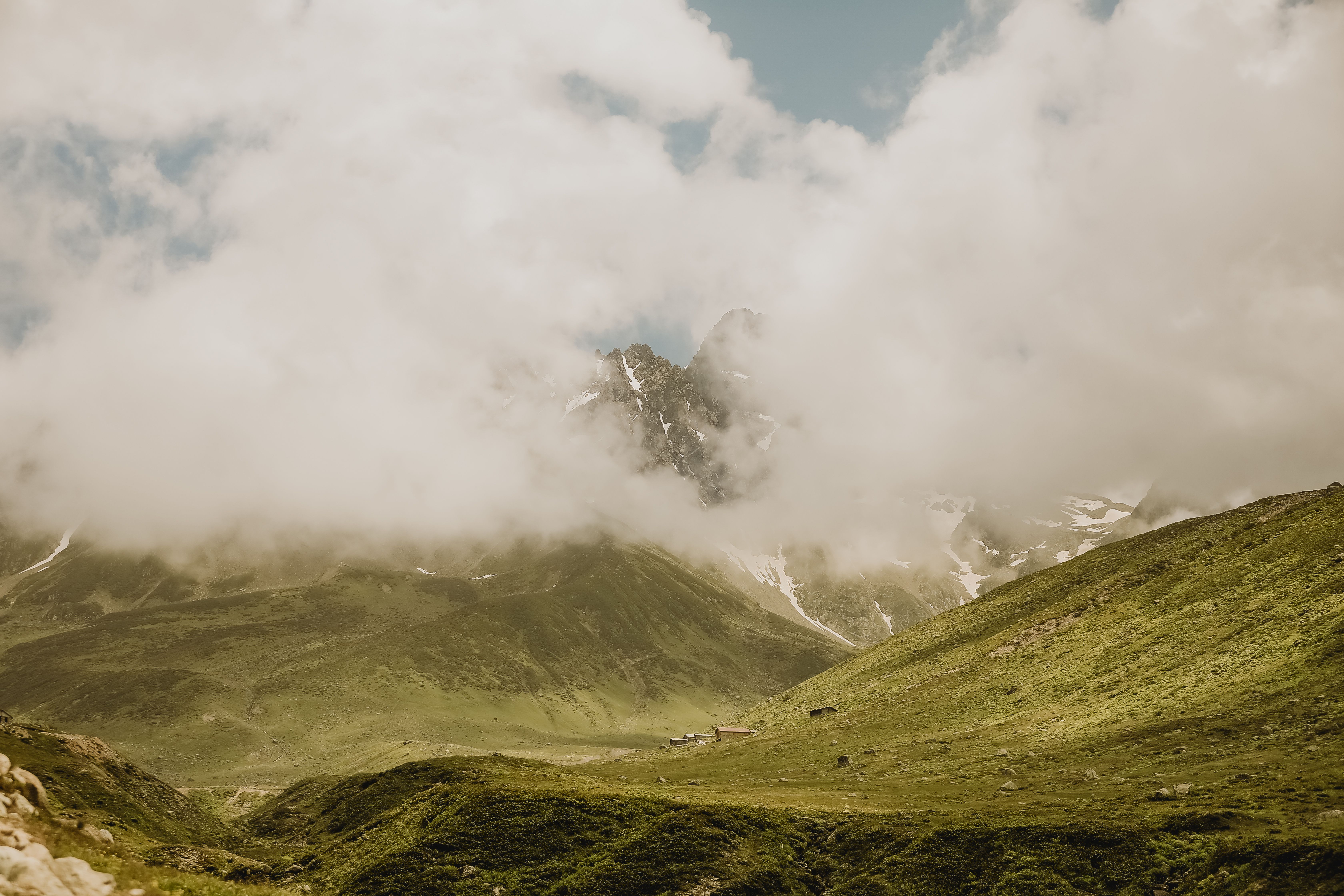 Fotomural Una vista impresionante de montañas cubiertas de niebla bajo un cielo claro de verano, perfecta para fotografía de viajes.