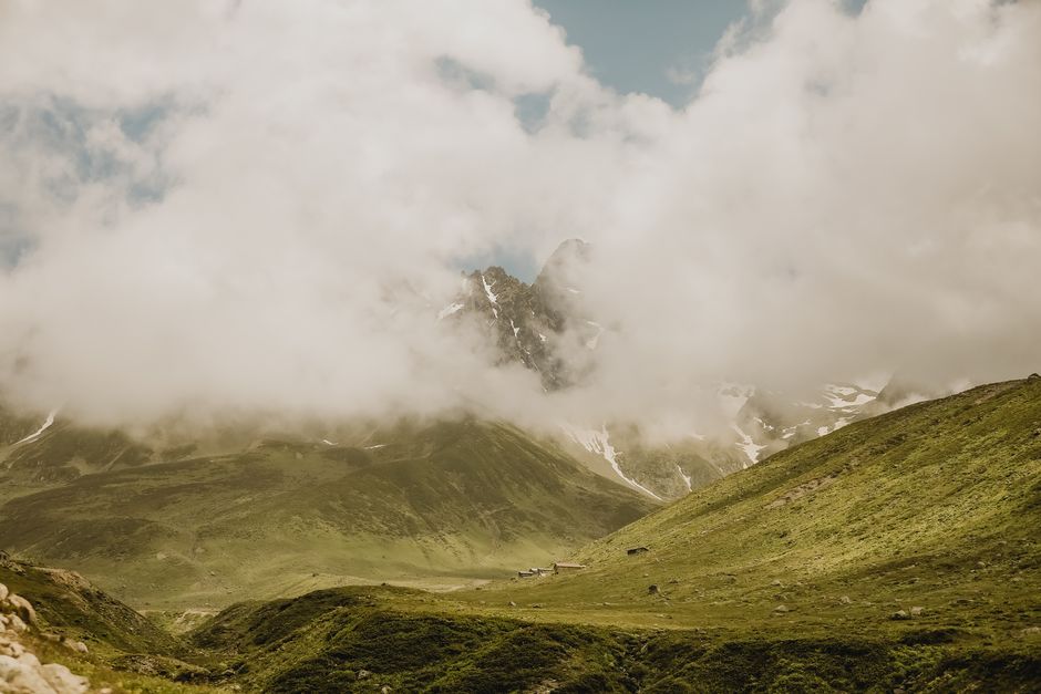 Fotomural Una vista impresionante de montañas cubiertas de niebla bajo un cielo claro de verano, perfecta para fotografía de viajes.